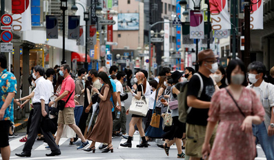 People walk at a crossing in Shibuya shopping area in Tokyo